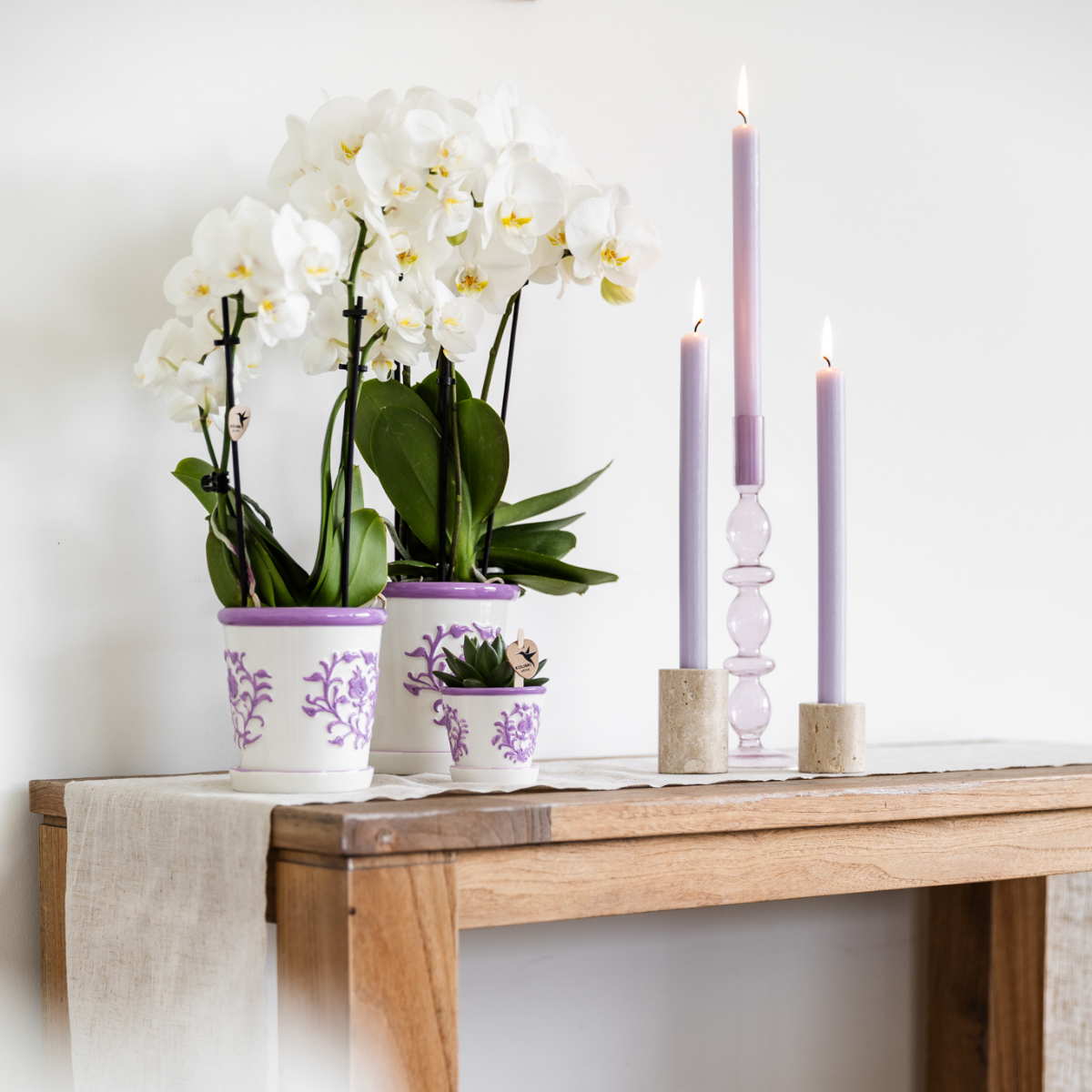 Everspring potten met paars gedecoreerd bloemmotief voor orchideeën en planten op houten tafel met kaarsen